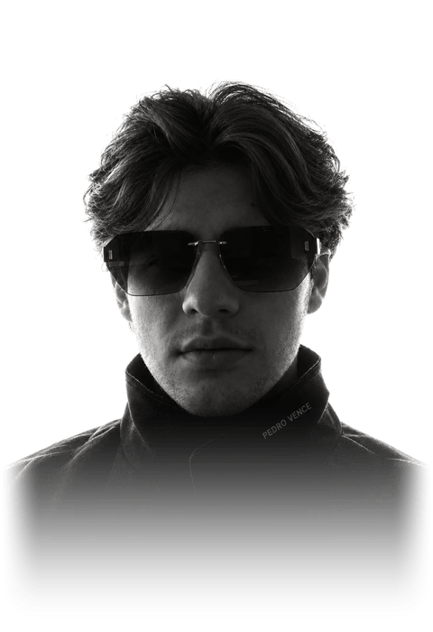 Retrato em preto e branco de Pedro Vence, de óculos escuros e jaqueta preta com o nome bordado na gola